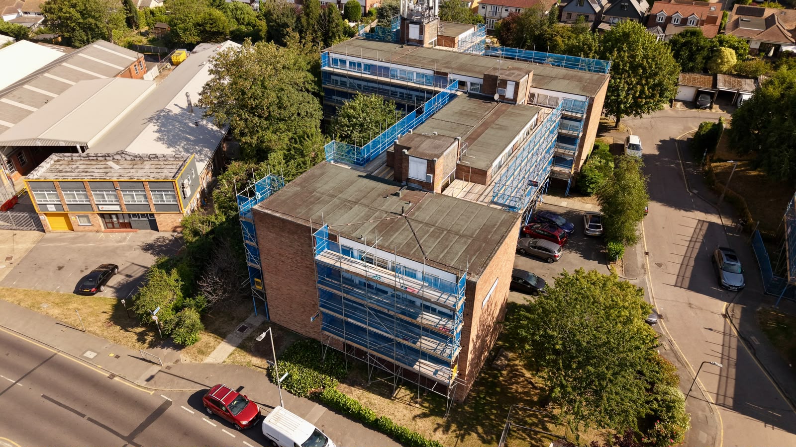 Aerial view of full-height scaffolding to a four-storey brick block of flats
