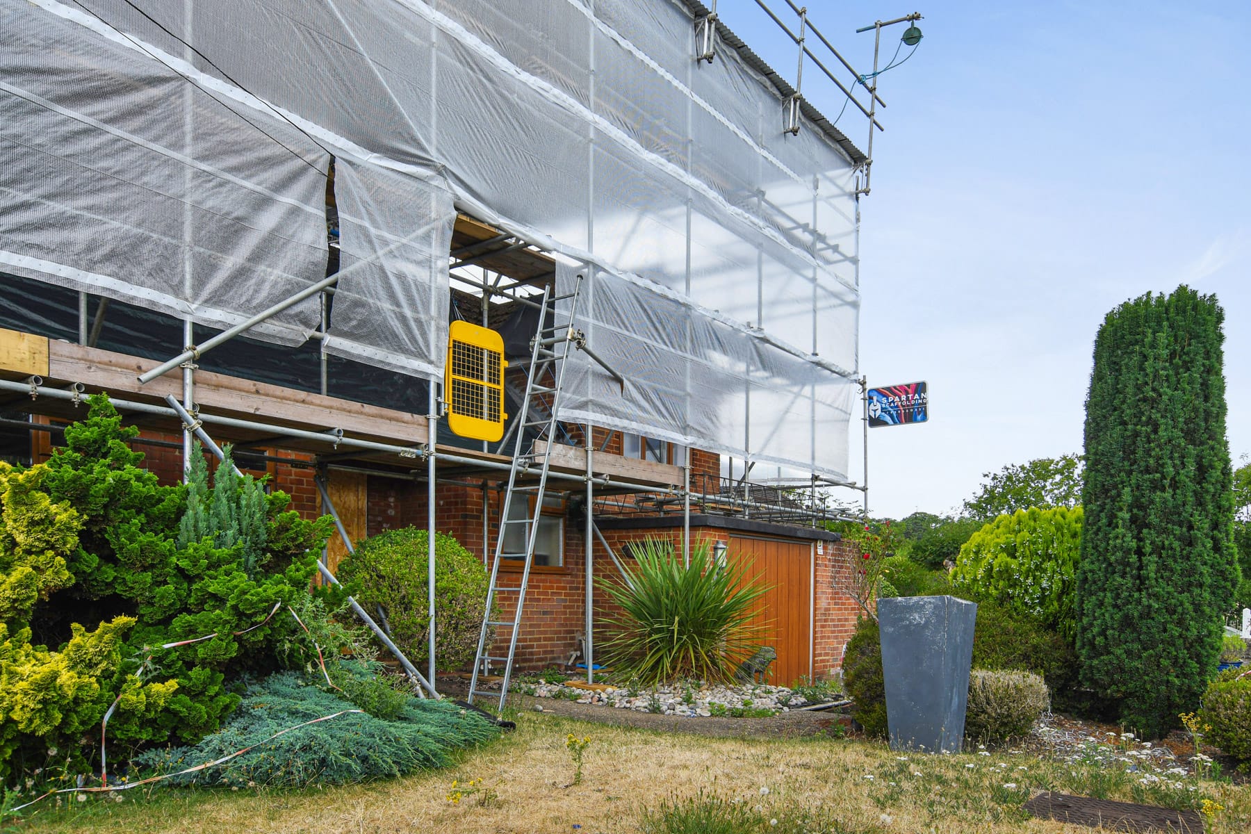 Residential house wrapped in scaffolding for renovation