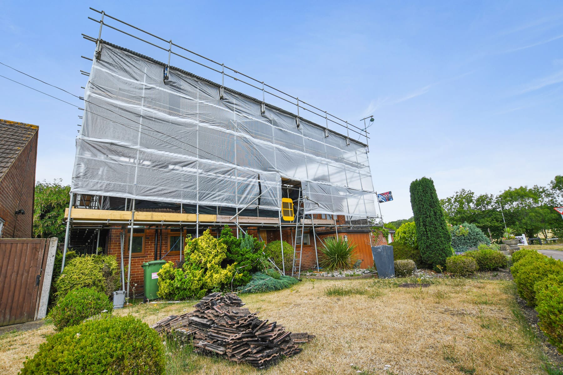 Sheeted residential scaffold with weather protection on a UK home