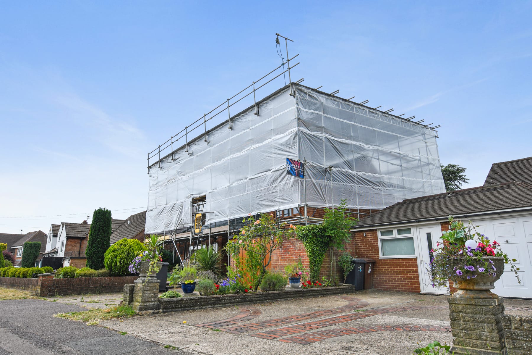 Residential scaffold encapsulated with sheeting for re-roofing
