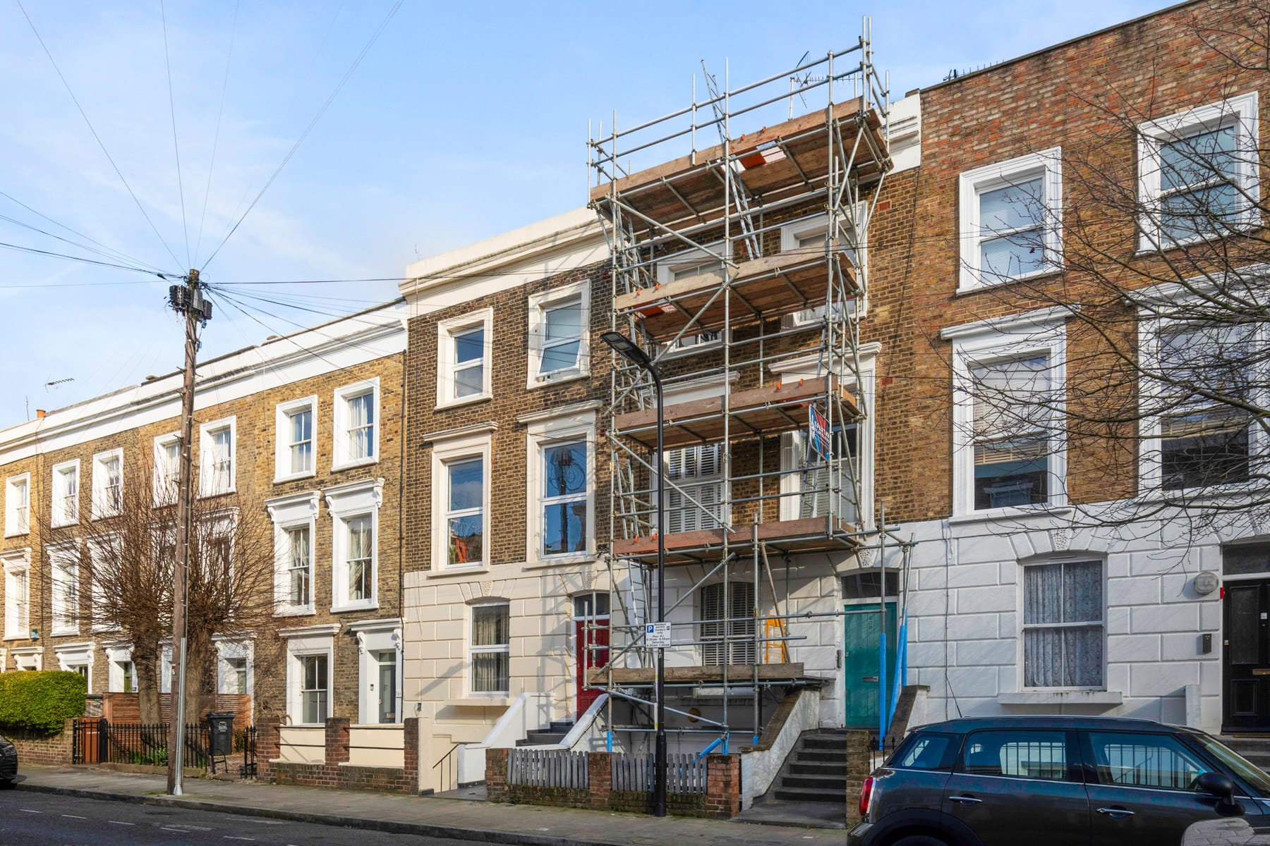 Large apartment building wrapped in heavy-duty industrial scaffolding